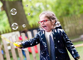 Highfield Pre-School pupil playing with bubbles