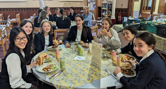 Upper 4 Harrogate Ladies' College pupils sit around a table for lunch at Resurrected Bites cafe