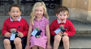 Highfield Prep School new starters sit on chapel steps with their hand-knitted teddy bears