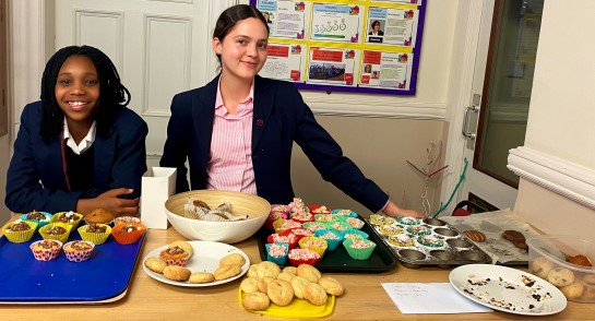 Boarders at Harrogate Ladies' College in the Boarding House kitchen alongside a selection of cakes and baked goods they created