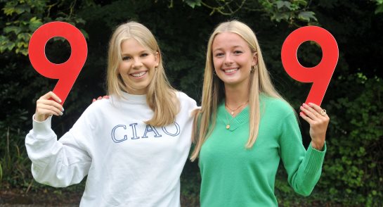 Two pupils celebrating fantastic GCSE results pose with number 9's