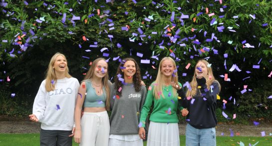 Pupils celebrating their GCSE results covered in confetti