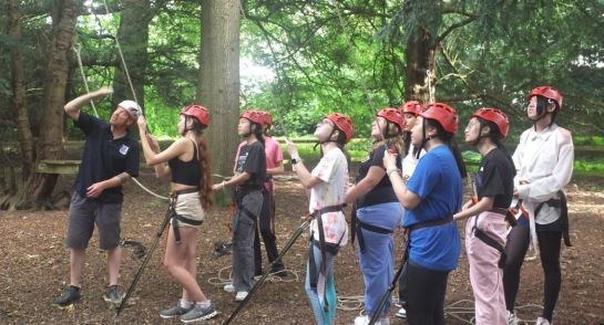 Lower 6 pupils at Log Heights, assisting with the ropes on the tree top adventure course