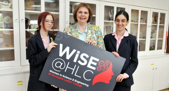 Principal, Sylvia Brett with pupils holding a WiSE@HLC poster